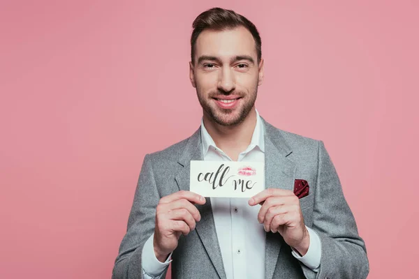 Bearded man holding valentines day card with call me sign, isolated on pink — Stock Photo