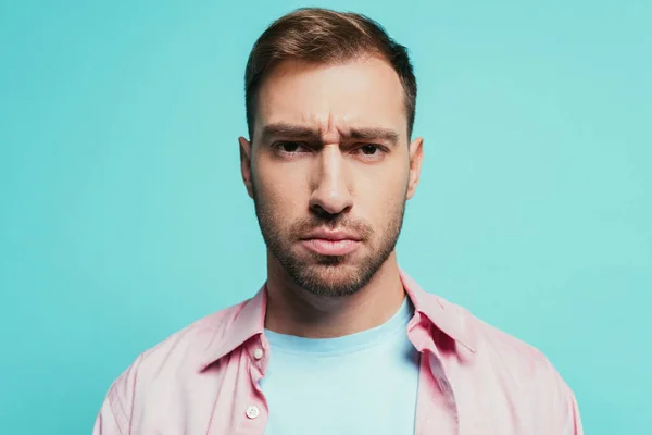 Retrato de un hombre guapo serio mirando a la cámara, aislado en azul - foto de stock