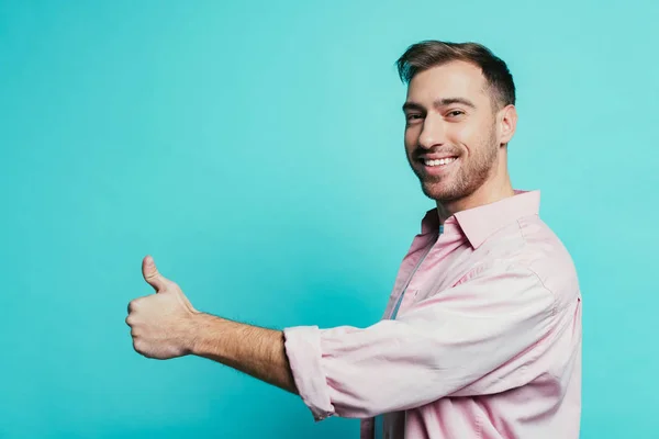 Happy handsome man showing thumb up, isolated on blue — Stock Photo