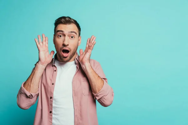 Sorprendido guapo hombre gritando aislado en azul - foto de stock