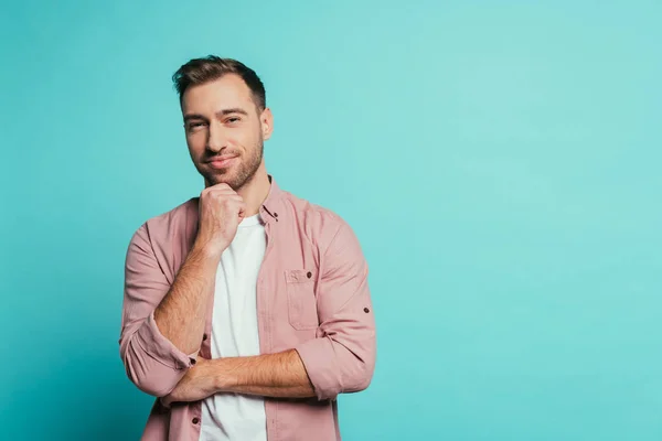 Cheerful handsome man thinking and looking at camera, isolated on blue — Stock Photo