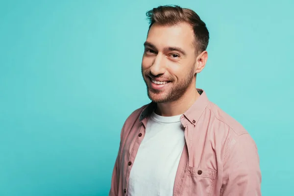 Cheerful handsome man smiling and looking at camera, isolated on blue — Stock Photo