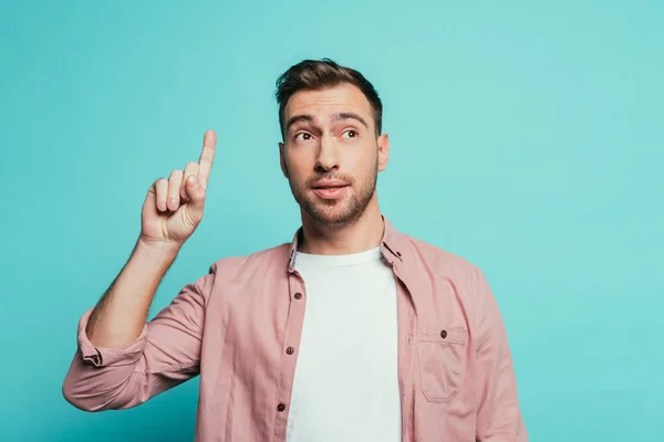 Handsome man showing fingers crossed, isolated on blue — Stock Photo