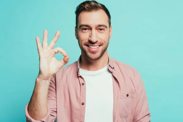 Cheerful handsome man showing ok sign, isolated on blue — Stock Photo