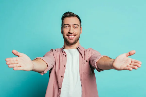 Sorrindo bonito homem gesticulando isolado no azul — Fotografia de Stock