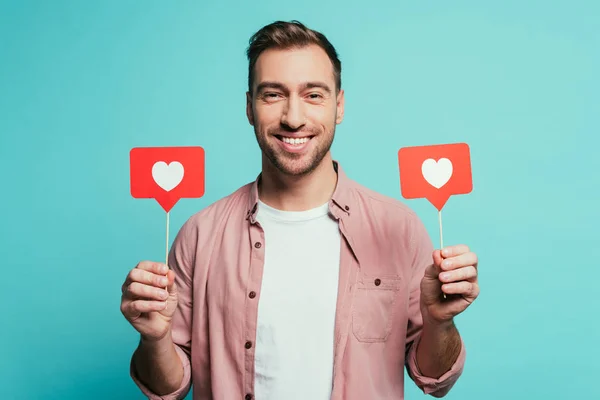 Lächelnder Mann mit Karten mit Herzen für den Valentinstag, isoliert auf blauem Grund — Stockfoto