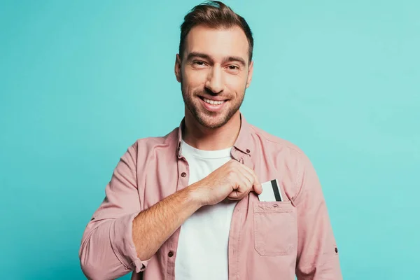 Sonriente hombre con tarjeta de crédito, aislado en azul - foto de stock