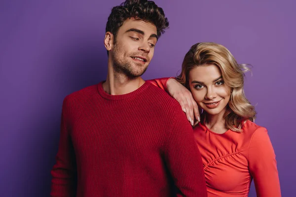 Happy girl leaning on shoulder of boyfriend on purple background — Stock Photo