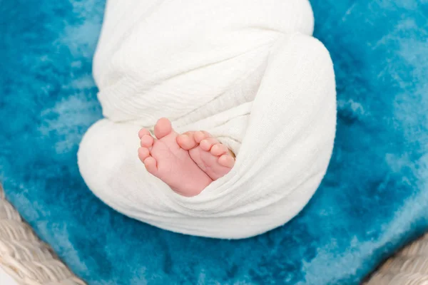 Cropped view of newborn baby wrapped in blanket lying in basket — Stock Photo