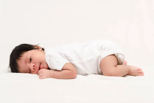 Adorable bi-racial newborn in baby romper lying isolated on white — Stock Photo