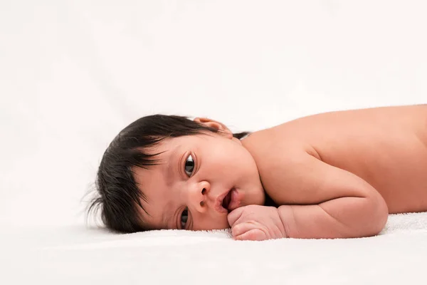 Adorable bi-racial and naked newborn baby lying on white — Stock Photo