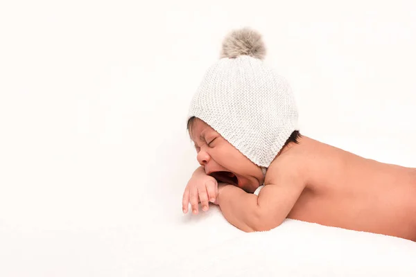 Adorable bébé de race mixte en bonnet tricoté bâillement isolé sur blanc — Photo de stock