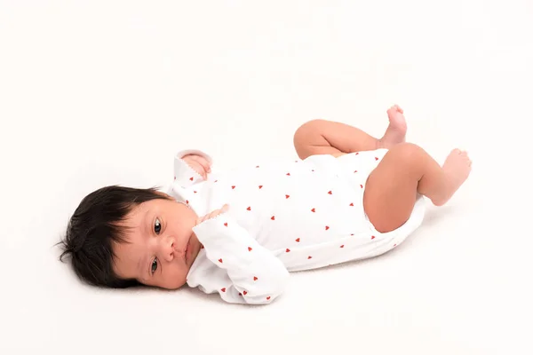 Adorable mixto raza recién nacido en bebé mameluco acostado aislado en blanco - foto de stock