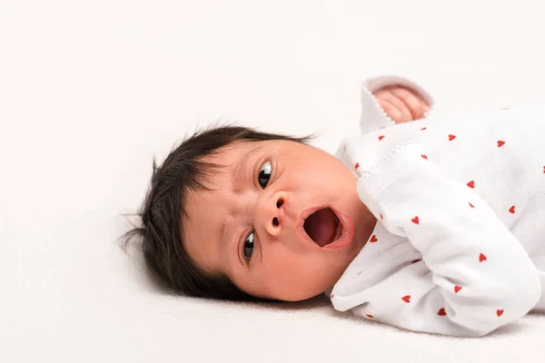 Adorable mixed race newborn in baby romper yawning isolated on white — Stock Photo