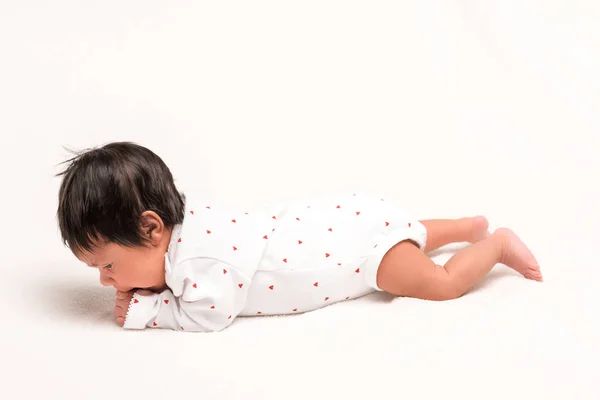 Bi-racial newborn in baby romper lying on white — Stock Photo