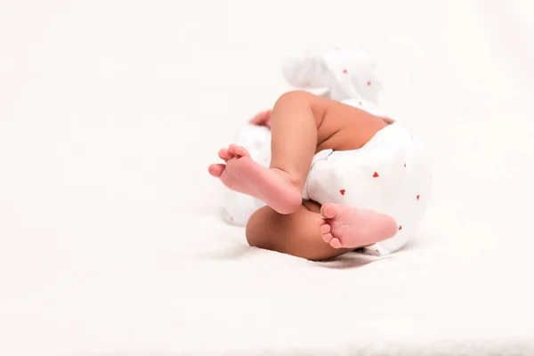 Carino neonato in pagliaccetto sdraiato sul bianco — Foto stock