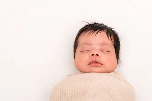 Blick von oben auf Mischlingsbaby in Decke gehüllt, schlafend isoliert auf weißem Grund — Stockfoto