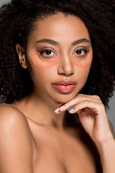 Ragazza afroamericana nuda con macchie oculari idrogel, isolata su grigio — Foto stock