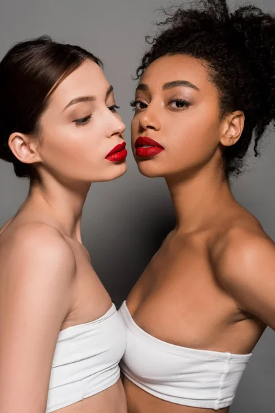 Chicas multiétnicas atractivas con labios rojos, en gris - foto de stock