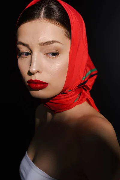Atractiva mujer elegante con bufanda roja, aislado en negro - foto de stock