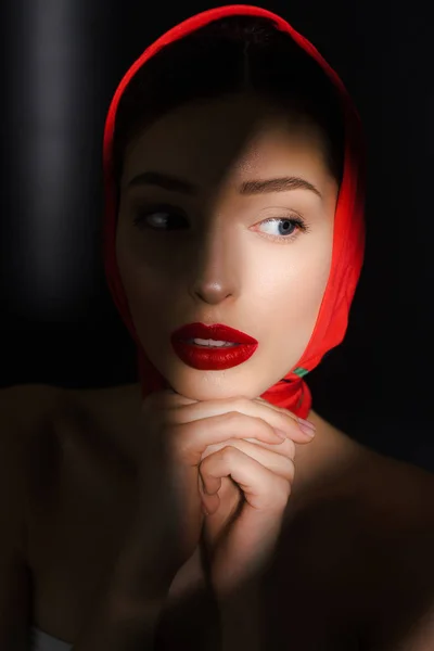 Портрет привлекательной элегантной девушки с красным шарфом, изолированный на черном — стоковое фото