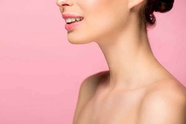 Обрезанный вид улыбающейся женщины с идеальной кожей, изолированный на розовый — стоковое фото