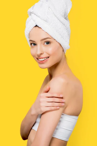 Menina sorridente atraente com toalha na cabeça, isolado no amarelo — Fotografia de Stock