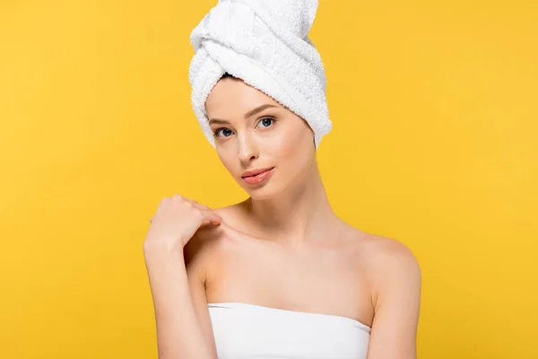 Портрет улыбающейся молодой женщины с полотенцем на голове, изолированный на желтом — стоковое фото