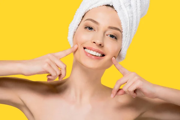 Портрет обнаженной улыбающейся девушки с полотенцем на голове, изолированной на желтом — стоковое фото