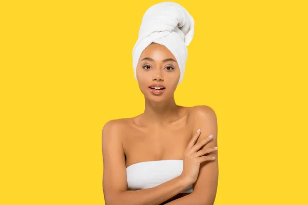 Attractive african american girl with towel on head, isolated on yellow — Stock Photo