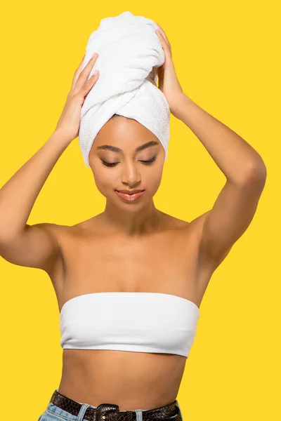 Porträt einer jungen afrikanisch-amerikanischen Frau mit Handtuch auf dem Kopf, isoliert auf gelb — Stockfoto