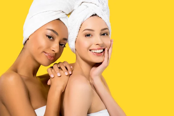 Retrato de sorridentes meninas multiétnicas com toalhas na cabeça, isolado em amarelo — Fotografia de Stock