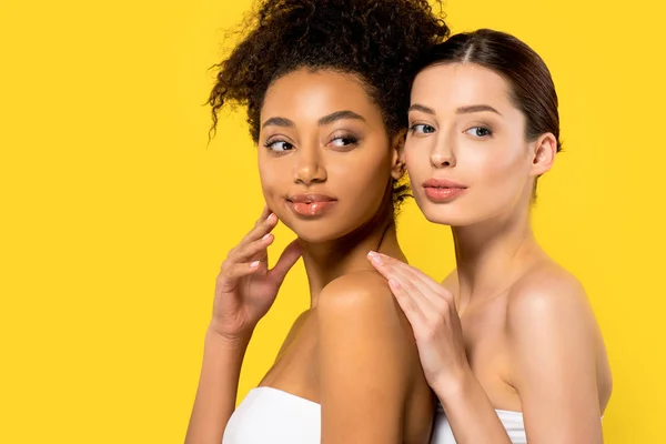 Retrato de hermosas chicas multiétnicas con la piel perfecta, aislado en amarillo - foto de stock