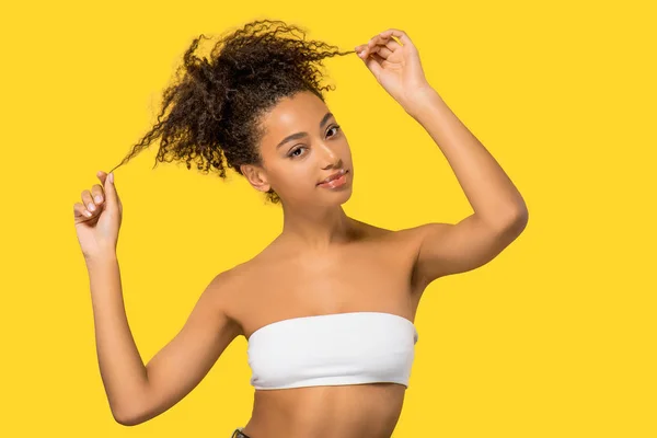 Retrato de niña afroamericana sonriente con el pelo rizado, aislado en amarillo - foto de stock