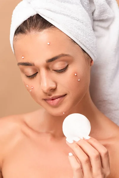Naked girl with acne on face looking at cotton pad isolated on beige — Stock Photo