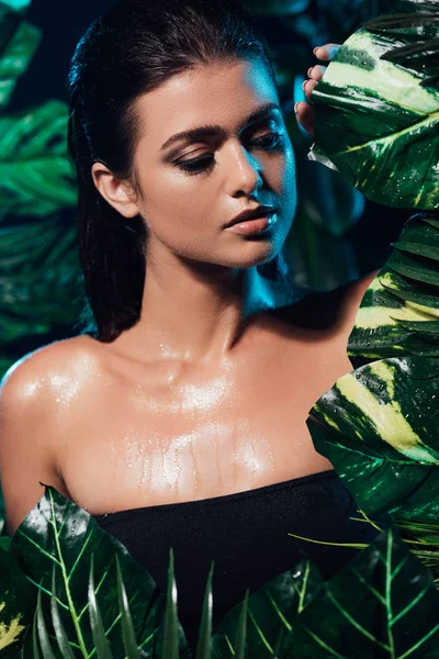 Sexy and wet young woman touching fresh leaves — Stock Photo