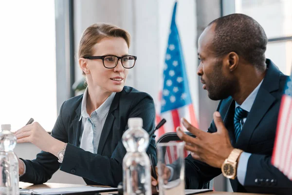 Enfoque selectivo de atractivo diplomático hablando con representante afroamericano - foto de stock