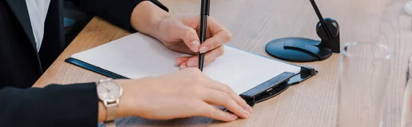 Panoramic shot of businesswoman holding pen near clipboard — Stock Photo