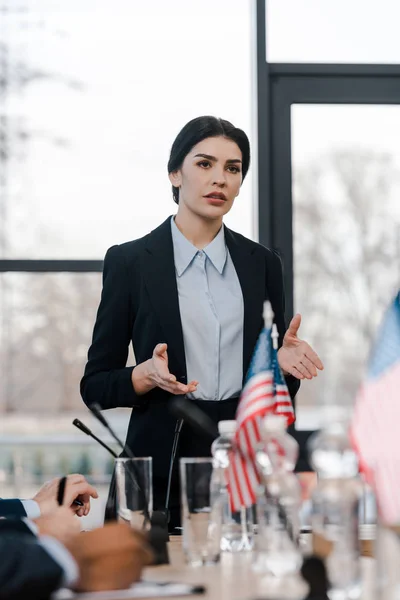 Selective focus of attractive speaker talking near multicultural diplomats — Stock Photo