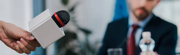 Panoramic shot of journalist holding microphone near diplomat — Stock Photo