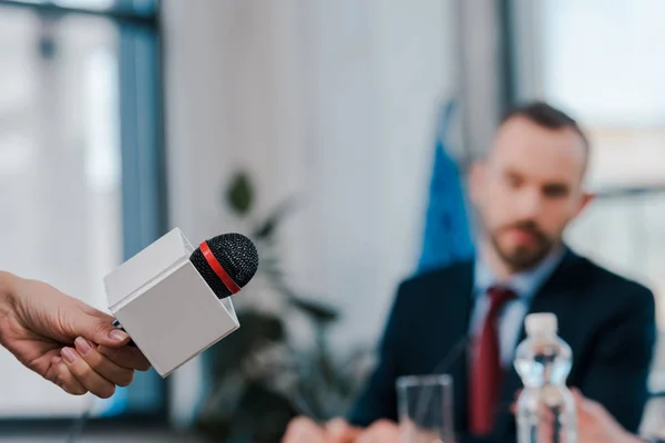 Selective focus of journalist holding microphone near diplomat — Stock Photo