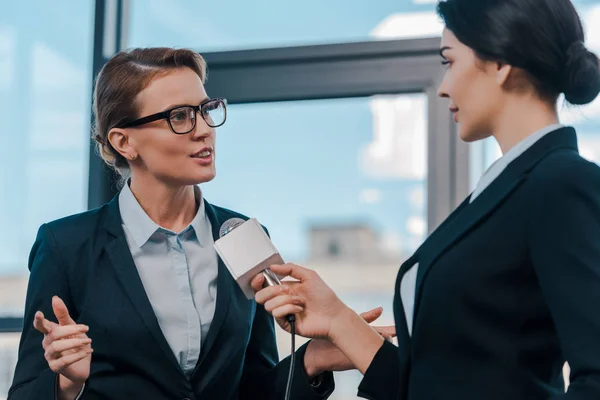 Selective focus of journalist holding microphone near attractive diplomat — Stock Photo