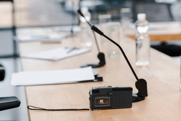 Селективное фокусирование диктофона рядом с микрофонами на столе — стоковое фото
