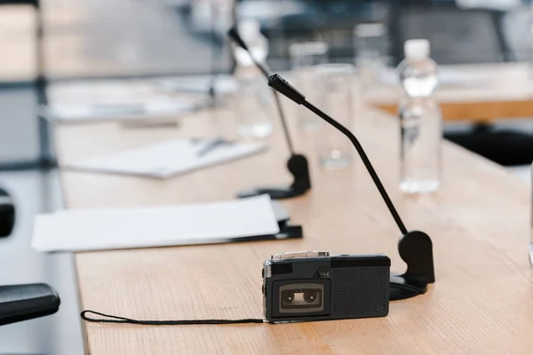 Enfoque selectivo de la grabadora de voz cerca de micrófonos en la mesa - foto de stock