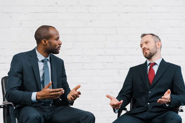 Beau homme d'affaires afro-américain gesticulant tout en regardant diplomate — Photo de stock