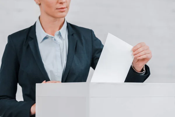 Cropped view of businesswoman voting near brick wall — Stock Photo