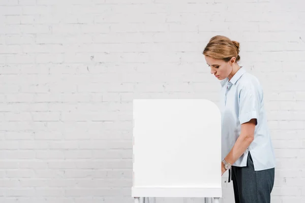 Schöne Frau, die in der Nähe von Stand und Ziegelmauer wählt — Stockfoto