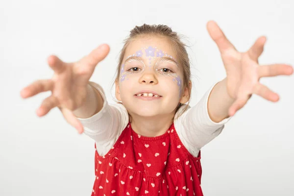 Adorable enfant avec peinture florale sur le visage étendant les mains à la caméra isolé sur blanc — Photo de stock