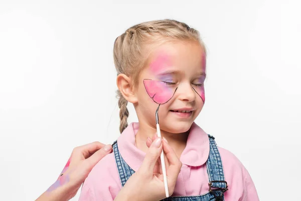 Vista ritagliata di artista pittura farfalla sul viso di adorabile bambino isolato su bianco — Foto stock