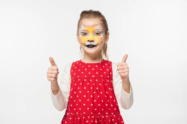 Happy child with tiger muzzle painting on face showing thumbs up isolated on white — Stock Photo
